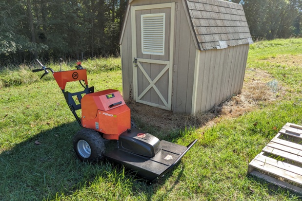 dr fb26e mower in front of shed
